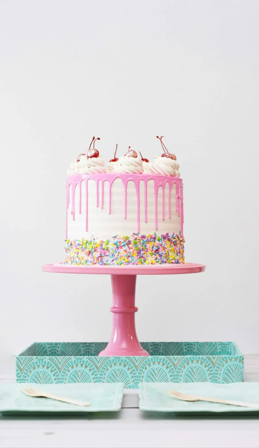 Tarta rosa con confeti en un soporte