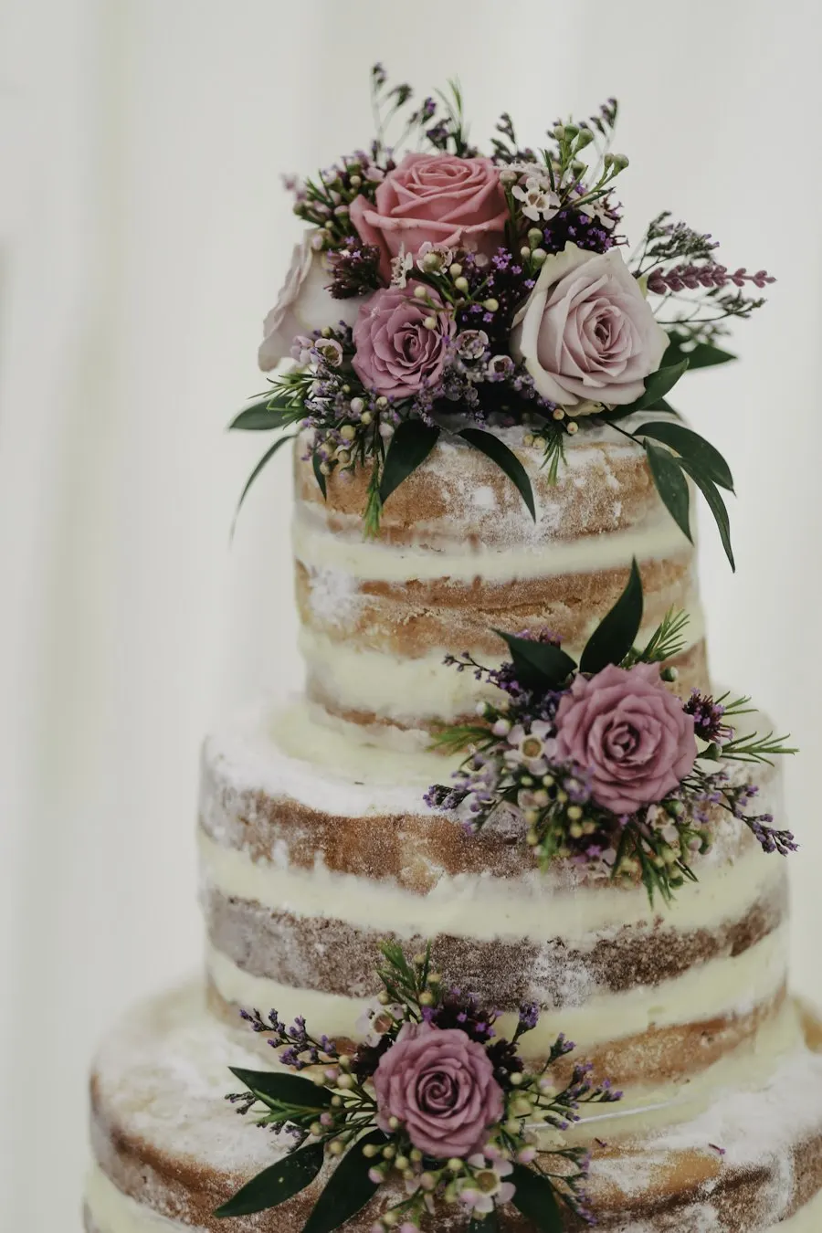 Tarta desnuda de tres pisos con flores moradas